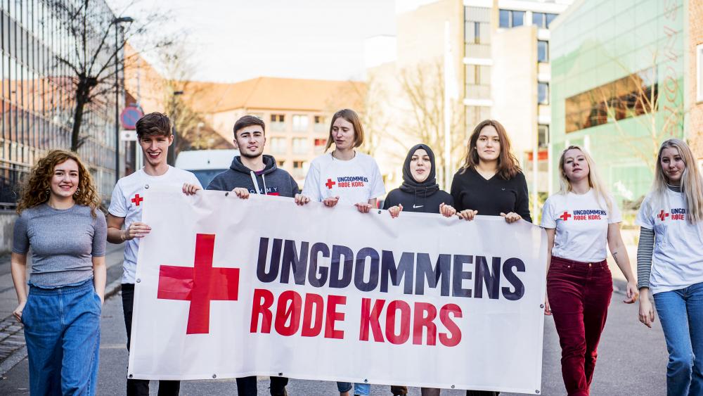 Unge frivillige med banner_Ungdommens Røde Kors