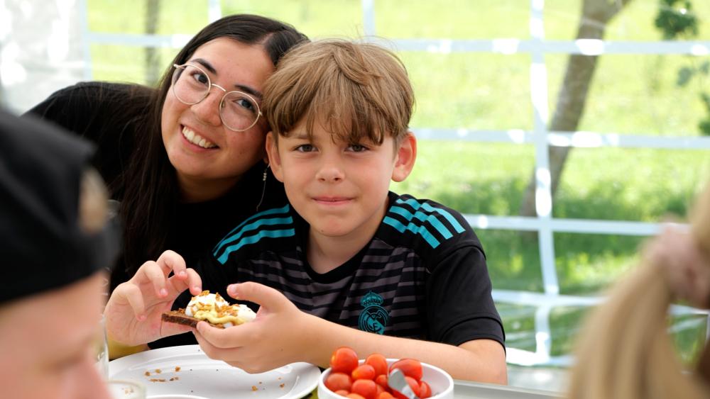 Foto af frivillig og barn på Ferielejr